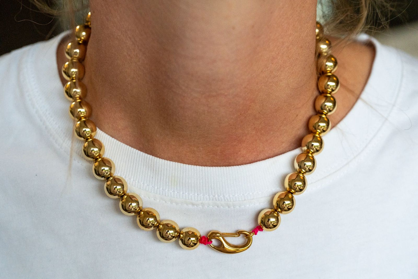 Goudkleurige statement ketting met gouden ballen en roze draad